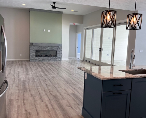 Custom Home Interior 6801 S Laguna Sioux Falls Custom home great room with stone fireplace dark kitchen island and hardwood floors built by Rosewood Homes Sioux Falls