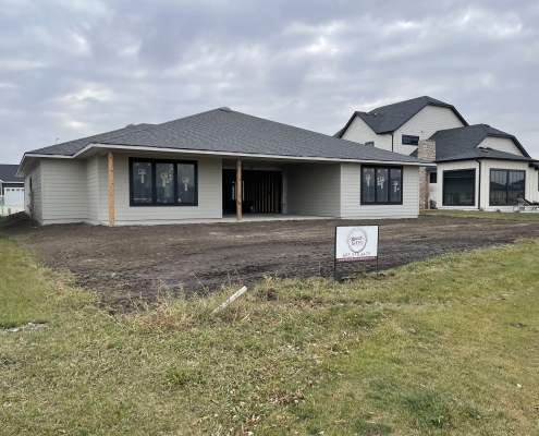Completed Custom Home Exterior Rosewood Homes Sioux Falls Recently completed Rosewood Homes custom home exterior with dark grey siding stone accents and professional landscaping Sioux Falls South Dakota