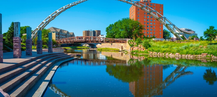 Summertime in Sioux Falls — downtown riverfront and Arc of Dreams sculpture at sunset